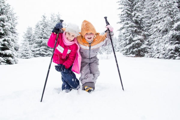 Kinder in verschneiter Winterlandschaft
